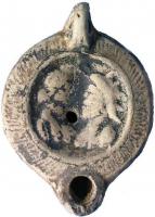 LMP-41885 - Lampe à bec rond : Isis et Sarapisterre cuiteLampe moulée, en argile rouge brique; bec cordiforme et anse verticale perforée; bordure d'oves, médaillon moulé représentant les bustes d'Isis couronnée et de Sarapis, coiffé du modius; au revers, fond annulaire et décor de pétales incisés sous le bec.