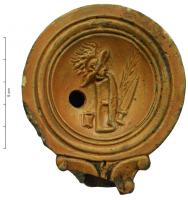 LMP-41957 - Lampe Loeschcke IV : Armes de gladiateursterre cuiteLampe à bec en ogive et volutes latérales; disque orné d'une frise d'armes de gladiateurs. Argile noisette, engobe orange foncé à marron foncé; base plate entourée d'un anneau en relief.