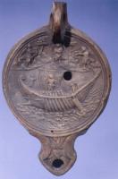 LMP-42029 - Lampe à bec ogival : Ulysse et les Sirènesterre cuiteLampe à bec ogival ; sur le médaillon, Ulysse attaché au mât de son navire ; autour de lui, Sirènes.
