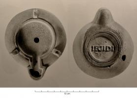 LMP-42062 - Lampe de firme : IEGIDIterre cuiteLampe à bec en ogive et canal de bec; disque lisse. Argile orange clair, engobe orange; sous la base, marque moulée IEGIDI ou IEGIDI.