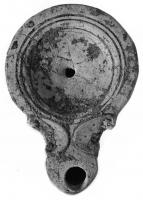LMP-4212 - Lampe Loeschcke IV terre cuiteLampe de Type Loeschcke IV, bec en ogive encadré de volutes. Disque sans décor, cerné par trois filets concentriques; bandeau plat et lisse.