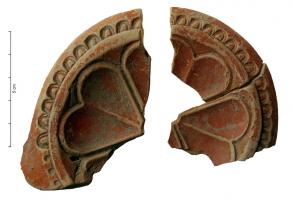 LMP-42230 - Médaillon de lampe : rosaceterre cuiteLampe à bec rond de type inconnu, à bandeau ornée d'oves et à médaillon orné d'un motif rosace constitué de quatre feuilles cordiformes.