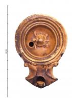 LMP-42256 - Lampe à bec angulaire à volutes simples : Tortueterre cuiteLampe moulée à bec angulaire à deux volutes simples se poursuivant sous le bec. Sans anse. Disque en cuvette limité par trois sillons concentriques. Bandeau, étroit et plat. Réservoir circulaire de profil tronconique. Décor : Tortue marine.