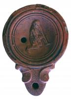 LMP-42336 - Lampe Loeschcke IV : Gladiateurterre cuiteLampe à bec à volutes. Médaillon décoré d'un gladiateur vaincu, en position agenouillée. Les bras sont couverts de protections à lamelles.