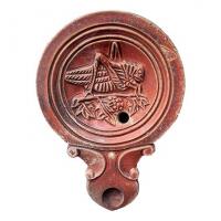 LMP-42392 - Lampe à bec en ogive à volutes doubles : Criquetterre cuiteLampe moulée à bec long en ogive à deux volutes doubles se poursuivant sous le bec. Sans anse. Disque en cuvette limitée par trois sillons concentriques. Bandeau plat. Décor : Criquet de profil droit.
