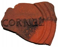 LMP-42500 - Lampe de firme : CORNELIterre cuiteLampe moulée de type Firmalampe. Base circulaire plate en creux limitée par deux anneaux concentriques enfermant l'estampille moulée CORNELI en relief. Pâte orange brique, sans engobe.
