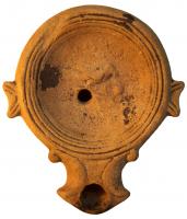 LMP-4301 - Lampe Loeschcke I : Oiseauterre cuiteLampe à bec à enclume et volutes latérales et ailerons; disque orné d'un oiseau sur branche picorant un fruit. Argile noisette, engobe orange foncé à marron foncé; base plate entourée d'un anneau en relief.
