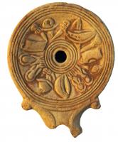 LMP-4305 - Lampe Loeschcke I : Armesterre cuiteLampe à bec en enclume et volutes latérales; disque orné d'une frise d'armes de gladiateurs. Argile noisette, engobe orange foncé à marron foncé; base plate entourée d'un anneau en relief.