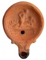 LMP-4370 - Lampe Loeschcke IV : scène érotiqueterre cuiteLampe à bec rond; disque orné d'une scène érotique. Argile marron clair à orangé, engobe perdue; base plate.