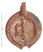 LMP-4377 - Lampe Loeschcke VIII : Sol et Sarapisterre cuiteLampe à bec rond; disque orné de Sol embrassant Sarapis. Argile orange engobe orange; base plate.