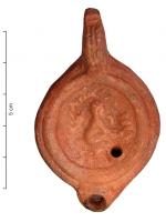 LMP-4443 - Lampe Loeschcke VIII : Harpocrateterre cuiteLampe à court bec rond. Sur le disque, Harpocrate nu, assis dans la nature. Argile orange, engobe orange; base plate.