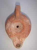 LMP-4445 - Lampe Loeschcke IV tardive terre cuiteLampe à bec en ogive et demi-volutes. Disque vierge, épaule décorée de pampres de vigne. Argile orange, engobe orange; base plate.