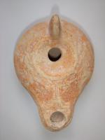 LMP-4446 - Lampe Loeschcke IV tardive terre cuiteLampe à long bec rond avec canal incisé. Disque vierge, épaule décorée d'une couronne végétale. Argile beige, engobe orange; base plate.
