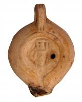 LMP-4447 - Lampe Loeschcke VIII tardive Amphoreterre cuiteLampe à court bec rond et canal. Disque décoré d'une amphore. Argile beige, engobe perdue; base plate.