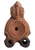 LMP-4463 - Lampe Loeschcke I tardive à deux becsterre cuiteLampe à double long bec à enclume et volutes internes. Disque vierge. Argile noisette, engobe marron; base plate. Anse à réflecteur triangulaire avec feuille.