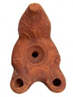 LMP-4465 - Lampe Loeschcke III à deux becsterre cuiteLampe à double long bec en ogive et volutes internes. Disque vierge Argile noisette, engobe orange-marron; base plate. Anse à réflecteur triangulaire avec palmette.