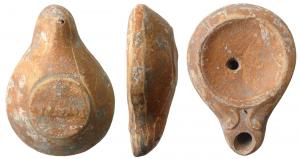 LMP-4554 - Lampe votive Loeschcke V : STROBILterre cuiteLampe sans anse, moulée, de taille réduite. Réservoir circulaire de profil biconique assymétrique. Bandeau étroit, penché vers l'extérieur, séparé du disque sans décor par un sillon. Bec moyen au bout en ogive flanqué au départ de deux volutes simples. Dans la base circulaire plate, marque en relief STROBIL, lisible bec en haut.