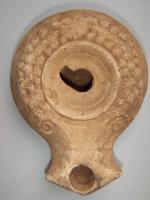 LMP-4698 - Lampe nabatéenne Negev Ic (Grawehr E.3, Sussman R10)terre cuiteLampe ronde à large bec à enclumes à demi-volutes. Epaule décorée d'une couronne de myrthe terminée à l'arrière par une fleur.