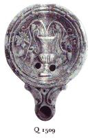 LMP-4744 - Lampe Loeschcke IV : Cratère et pampresterre cuiteLampe ronde à large bec en ogive à volutes. Médaillon décoré d'un cratère dont jaillissent des pampres de vigne.