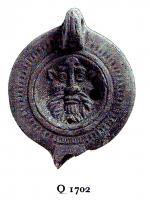 LMP-4802 - Lampe Loeschcke VIII - Satyre ou faune, LVCCEIterre cuiteLampe ronde à bec rond défini par un trait incisé horizontal. Médaillon orné d'un masque de satyre, épaule ornée de traits imprimés. Marque LVCCEI imprimée sur la base.