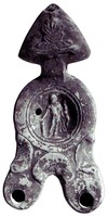 LMP-4846 - Lampe Loeschcke III à deux becs : Herculeterre cuiteLampe ronde à deux longs becs en ogive à volutes. Médaillon décoré d'Hercule tenant la massue et l'arc. Anse plastique triangulaire décorée d'une palmette.