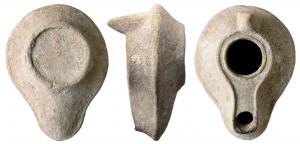 LMP-5030 - Lampe syro-palestinienne à canalterre cuiteAnse en tenon conique. Réservoir piriforme de profil biconique. Palme en relief sur le bandeau. Grand trou d'alimentation bordé par un bourrelet, entouré par une gouttière. Le bourrelet qui la limite se poursuit de long d'un canal sur le bec. Base circulaire plate entourée par un bourrelet en relief.