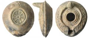 LMP-5038 - Lampe syro-palestinienneterre cuiteAnse en tenon conique. Réservoir crculaire de profil biconique. Croisillon en relief sur le bandeau. Grand trou d'alimentation bordé par trois bourrelets concentriques, entouré par une gouttière. Le bourrelet qui la limite se poursuit de long d'un petit canal sur le bec. Base circulaire plate entourée par un bourrelet en relief contenant une roue à huit rayons.