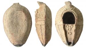 LMP-5045 - Lampe syro-palestinienneterre cuiteMoulée. Anse en petit tenon applati relevée. Réservoir ovoïde de profil biconvexe. Bandeau au décor de traits rayonnants d'éléments quadrillés et de deux palmes le long du bec Grand trou d'alimentation en fer à cheval entouré de deux fins bourrelets. Bec en V entouré par un bourrelet ; quatre cercles pointés en relief sur le desssus. Base plate sans délimitation. 