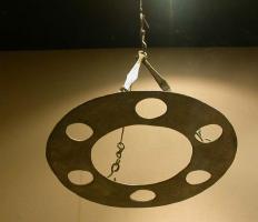 LUS-5002 - LustrebronzeLustre constitué d'un simple anneau (plaque épaisse) ajouré d'orifices circulaires pour l'insertion de lampes en verre; suspension à chaînettes, utilosant éventuellement des éléments allongés en tôle et percés aux extrémités.
