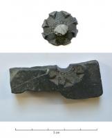 MOU-9005 - Moule : fusaïolepierreTPQ : 1500 - TAQ : 1700Moule en pierre fine, creusée d'empreintes pour la coulée de fusaïoles en plomb, ornées de nodosités angulaires sur un semis de traits entrecroisés; un moule complet utilisait deux valves ainsi qu'un axe pour conserver vide l'axe des fusaïoles.