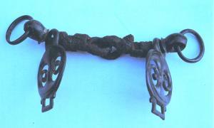 MRS-4002 - Mors à appliques latéralesbronzeTPQ : 200 - TAQ : 300Mors à appliques latérales coulées comportant une partie principale décorée et  deux bélières opposées (une ronde pour le mors et une rectangulaire pour les brides).