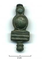 PDH-4043 - Extrémité de lanièrebronzePendant enserrant l'extrémité d'une lanière, prolongée par une plaquette transversale et un bouton moulurés; la fixation sur le cuir est rivetée.