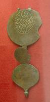 PDH-4097 - Pendant de harnaisbronzeApplique de harnais composée de trois éléments superposés : un pendant sommital, suspendu par deux languettes percées, et simplement orné d'un disque (mouluré ou poinçonné); en dessous, une languette axiale, tout en maintenant un élément circulaire, soutient un pendant à crochet, cordiforme, classiquement équipé d'un lest à la base.