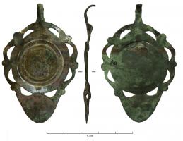 PDH-4102 - Pendant de harnais à crochetbronzePendant en tôle, de forme générale circulaire (avec un décor rapporté au centre, souvent réduit à une trace de brasure, dans un groupe de cercles incisés), avec à la base une partie plus allongée formant une pelte; tout autour, ajours découpés en arcs de cercles.