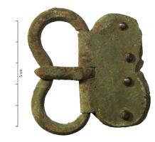 PLB-4050 - Plaque-boucle articulée à plaque ovale ou bilobéebronzePlaque-boucle à plaque ovale ou bilobée (dans ce cas les deux éléments sont réniforrmes et symétriques) : boucle fortement rentrante au niveau du repos d'ardillon, plaque articulée ovale à partie arrière éventuellement bilobée; 2, 3 ou 4 rivets en bronze, parfois en argent; les angles de la boucle sont généralement chanfreinés.