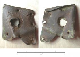RRL-8001 - Renfort de reliurebronzeRenfort en tôle, époussant l'angle d'une reliure à ais de bois et comportant généralement, à l'opposé de l'angle protégé, une découpe en forme de feuille, ou de fleur de lis. Dans l'angle, une bossette emboutie en fort relief permettait de protéger les plats de la reliure.