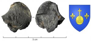SCL-9078 - Plomb de fabrique : Montagnac (Hérault)plombPlomb à anneau riveté, portant d'un côté, dans un cadre ovale, les armes de Montagnac (Golgotha entouré de deux fleurs de lis); de l'autre, blason royal aux 3 fleurs de lis.