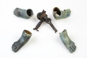 SIE-4007 - Siège à extrémités en forme de pied humainbois, cuir, bronzeSiège pliant formé par quatre hampes en bois, maintenues par une articulation en fer (parfois par quatre pitons à doubles pointes passant dans un anneau). Deux pieds droit et deux pieds gauche humain en ronde-bosse sont fixés sur l'extrémité inférieure des hampes. Certains pieds sont nu et d'autres sont chaussés d'une sandale.