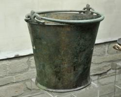 SIT-3028 - Situle tronconiquebronzeSitule tronconique à paroi rectiligne (forme de 'kalathos'), le fond en léger bourrelet répond au bord épaissi; sur la lèvre, deux attaches en double œillet reçoivent deux anses libres, aux extrémités recourbées.