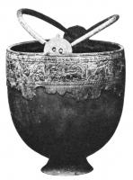 SIT-4042 - Situle de type Hemmoor, à reliefsbronzeSitule de fome hémisphérique avec une lèvre droite, épaissie et moulurée à l'extérieur, d'où émergent deux appendices doublement percés dans lesquels jouent deux anses à terminaison en crochets; sous la lèvre, frise incisée ou en très léger relief : poursuite d'animaux, chasse... ; pied tronconique.