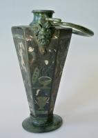 SIT-4050 - Vase hexagonalbronzeVase à panse hexagonale, constitue de 6 pans trapézoïdaux à motifs incrustés d'argent : Amours, coq et aigle sur un autel, paon sur une coupe; sur le sommet également hexagonal, guirlande et buste; anse mobile fixée par deux attaches à tête de Pan; pied annuaire circulaire.