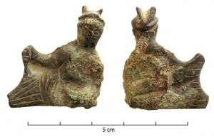 STE-4008 - Statuette : Hermès - Mercure en banqueteurbronzeTPQ : 1 - TAQ : 100Petite figurine aplatie et légèrement courbe, dont la base plate indique une fixation par brasure sur un bord circulaire : décor de vase ...? Elle représente un banqueteur (parfois identifié à Mercure grâce à un pétase ailé) étendu sur le côté, parfois torse nu, le haut du corps appuyé sur le coude gauche, retenant son vêtement de la main droite. Certains exemplaires sont dépourvus d'ailettes, le banqueteur n'étant alors pas identifiable.