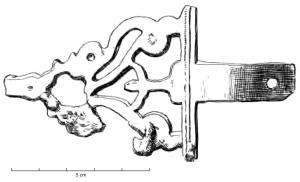 AGC-3020 - Agrafe de ceinturebronzeAgrafe de ceinture triangulaire, à languette perforée, comportant plusieurs ajours dessinant des motifs symétriques autour d'un sujet central qui est peut-être d'inspiration anthropomorphe.