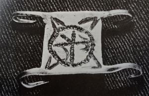 AGR-4007 - Agrafe à quatre crochetsargentAgrafe à corps rectangulaire plat, décor généralement centré sur un motif circulaire. Les angles sont prolongés par quatre crochets acérés, repliés vers l'arrière.