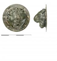 APM-4083 - Applique de meuble : tête de Méduse (gorgoneion)bronzeApplique circulaire de grande taille, avec un rebord étroit; revers creux sans autre mode de fixation que la fente sommitale dans le bord de l'objet, sur laquelle est parfois conservée un crampon replié sur lui-même. le décor figure, généralement dans un style très soigné, une tête de Méduse surmontées d'ailerons. Le crampon sert parfois à fixer aussi un anneau articulé qui encadre le médaillon.