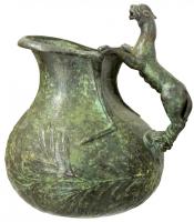 ASK-9001 - Askos à décor moulé (faux)bronzeTPQ : 50 - TAQ : 150Askos (cruche en forme d'outre) à panse peu déformée latéralement, mais ornée de reliefs moulés, d'inspiration végétale et dionysiaque; anse rapportée en forme de panthère (corps entier).