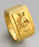 BAG-4421 - Bague à chaton mouléorBague dont le chaton très élargi forme un plateau rectangulaire plat et lisse, au milieu duquel se détache un cadre rectangulaire en relief, portant un décor variable (buste, dextrarum iunctio…). L'anneau peut être orné de motifs incisés ou même travaillé en opus interrasile.