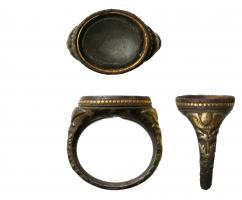 BAG-8009 - Bague à jonc ornébronzeBague à jonc ovale concave (pierre ? émail ? loge pour chaton ?); de part et d'autre le jonc est orné de motifs figurés : ange ... etc.