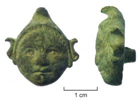 CLD-4073 - Clou décoratif : tête d'Attis
bronze
Clou décoratif, entièrement en bronze, représentant une tête d'enfant coiffé d'un bonnet phrygien. Cheveux représentés sous la forme d'une frise de demi-cercles. Bonnet décoré d'une ligne de 4 points encadrée par deux lignes de 5 croix gravées.