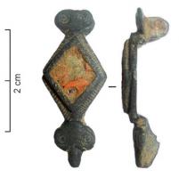FIB-41009 - Fibule symétrique émailléebronzeFibule dont l'arc est composé d'un losange creusé d'une loge unique émaillée; la tête et le pied sont composées de tête de reptiles stylisés, qui assurent la symétrie.